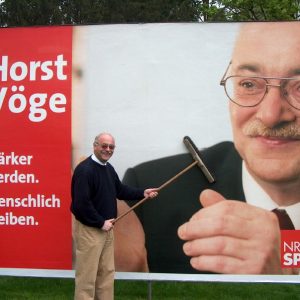 MdL Horst Vöge beim kleben von Plakaten